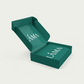 A green rectangular Datekin Sample Box labeled LAMA in white, featuring the SPD60 model. Its open lid reveals an intricate design, ideal for gifting Sukkari Pitted Dates, set elegantly against a white backdrop.